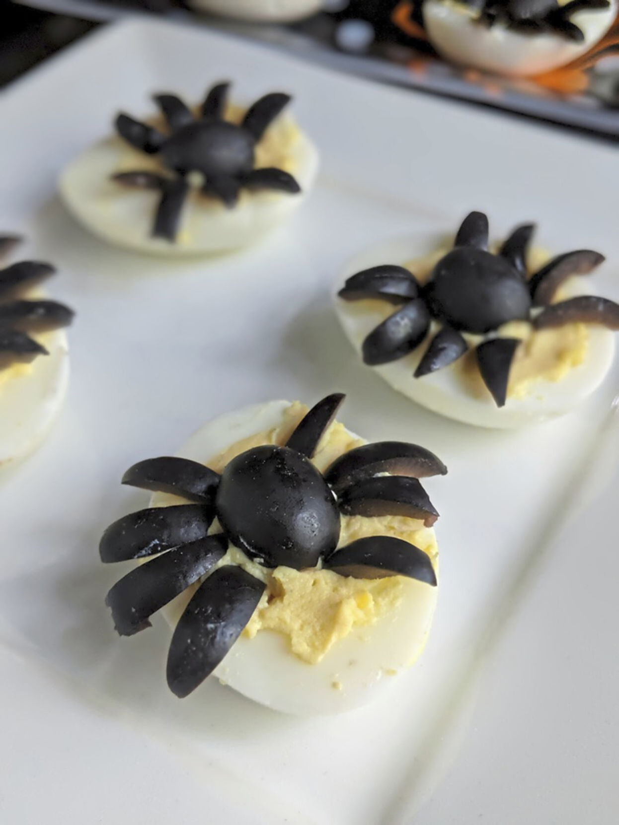 Sliced black olives turn a standard deviled egg into one that looks like a spider.